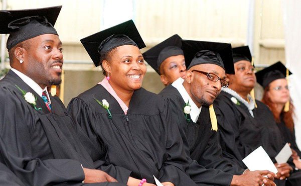 Graduates from Pine Street Inn’s job training program listen to speakers during a recent graduation ceremony. The graduates, all homeless men and women, ranging in age from 20s to 60s, wore caps and gowns to celebrate the completion of the program, which featured training in food services, building maintenance and housekeeping.