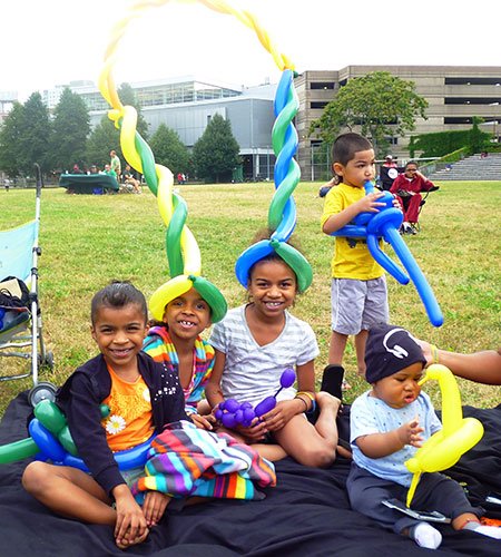 Yemilys Hernandez, 5, with her sisters Yaslaniz, 6, Yisarielie, 8, and Jose Ocasio, 3, all of the South End play with their free balloon creations at a ParkARTS Neighborhood Concert on July 22 at Carter Playground in the South End. The Mayor’s Neighborhood Concerts feature a variety of music artists at parks throughout Boston until August 4. The event was sponsored by the Boston Parks and Recreation Department and in partnership with Bank of America and Northeastern University’s City and Community Affairs. For information on more Boston Parks and Recreation Department events, please visit www.cityofboston.gov/parks.