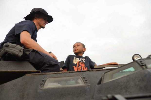 Joshua Jamieson, 8, talks with Officer Matt Jordan, a member of the Laurel, Md., Police Department SWAT team, atop an armored vehicle at the town's annual National Night Out in Granville Gude Park on Tuesday, Aug. 6. The yearly event gives Laurel's law enforcement and rescue personnel an opportunity to meet with the community.