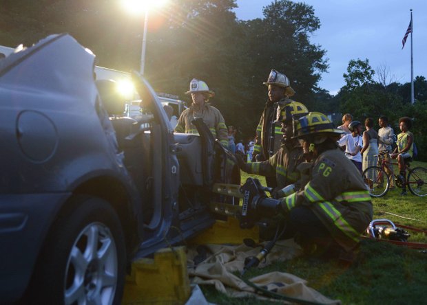 Members of the Laurel, Md., volunteer fire department dismantle a vehicle during a demonstration at the town's annual National Night Out in Granville Gude Park on Tuesday, Aug. 6. The yearly event gives Laurel's law enforcement and rescue personnel an opportunity to meet with the community.