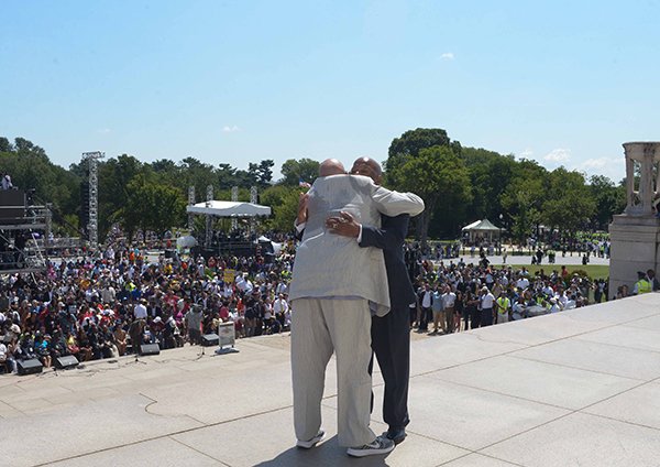Radio personality Tom Joyner (left), hugs Rep. John Lewis (D-GA), on the steps of the Lincoln Memorial at the March on Washington 50th Anniversary on Sat., August 24.