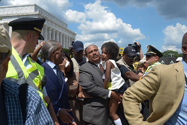 Martin Luther King III carries his daughter to the march starting point at the Lincoln Memorial after remarks reflecting on Dr. King's legacy at the March on Washington 50th Anniversary on Sat., August 24.