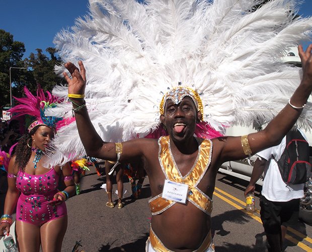 Boston Socaholics band leader Derric Sealy gets into the spirit of Carnival, leading his dancers in the parade to Franklin Park.