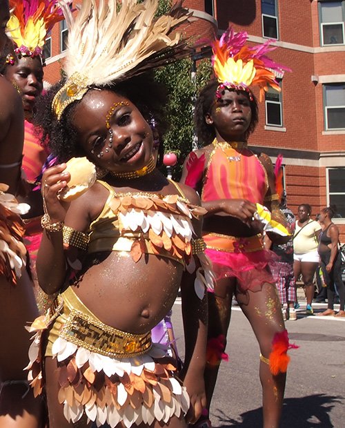 Five-year-old Kalaiya Marshall Akhia (front) dances with Boston Socaholics. The Socaholics’ 2013 theme was “Sweet Escape.”