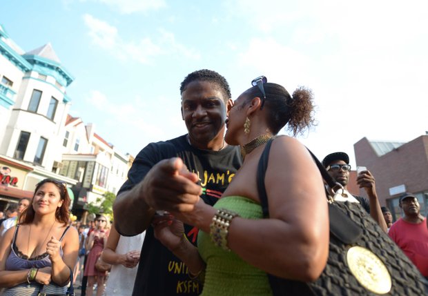 Tommy (left) catches a photographer trying to capture a candid photo of him and his dance partner, Sylia, at Adams Morgan Day in D.C. on Sunday, Sept. 8.
