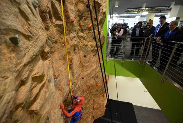 A man dressed as Spider-Man climbs the rock wall at the newly refurbished Anthony Bowen YMCA in Northwest D.C. after a ribbon-cutting ceremony on Monday, Sept. 9.