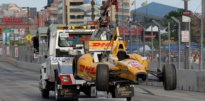 A DHL race car being towed away after an accident