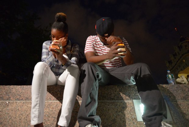 Jibir Johnson (right), 24 of Lanham, Md., and Brittnay Carter, 24 of Lanham, listen to speakers during a candlelight vigil at Freedom Plaza in Northwest on Monday, Sept. 16, to honor the victims of the Washington Navy Yard shooting.