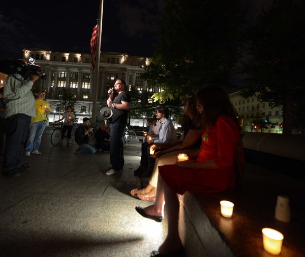 Eddie Weingart, 34, center, speaks to a small crowd gathered for a candle light vigil honoring the lives and shooting victims of the Navy Yard shooting at Freedom Plaza in Northwest on Monday, September 16.