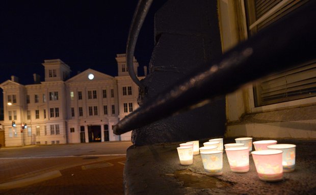 Candles sit on a window ledge facing the Washington Navy Yard before the start of a vigil for the victims of the Navy Yard shooting on Tuesday, Sept. 17. The vigil was hosted by Project End Gun Violence.
