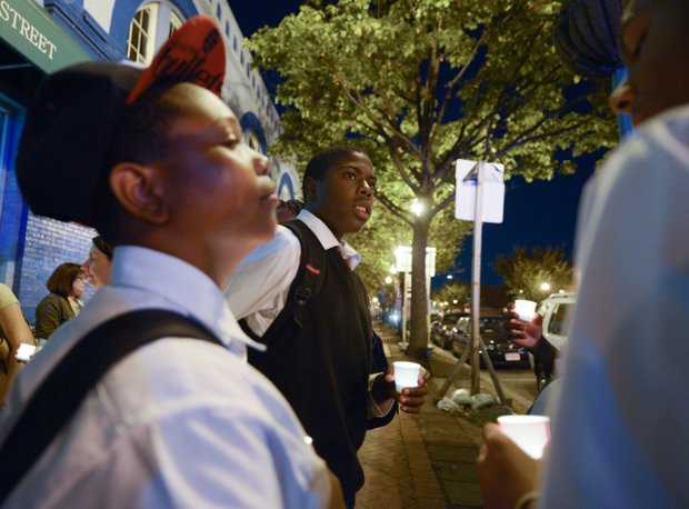 Dwayne Brooks (center), 15, a student at the Richard Wright Public Charter School for Journalism and Media Arts in D.C., stands in silence during a candlelight vigil for the victims of the Washington Navy Yard shooting at 8th and M streets in Southeast on Tuesday, Sept. 17.