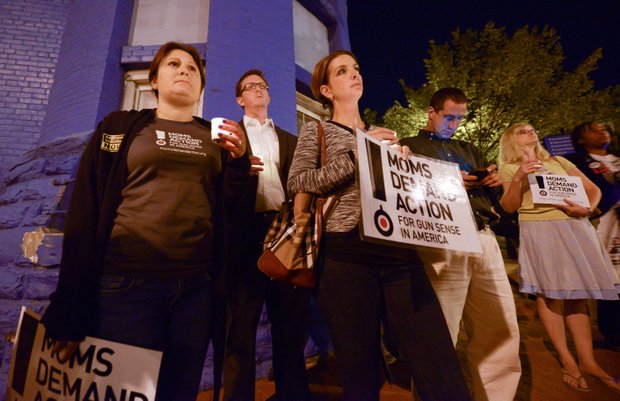 A small group organized by Project End Gun Violence offers their respects during a candlelight vigil for the victims of the Washington Navy Yard shooting at 8th and M streets in Southeast on Tuesday, Sept. 17.