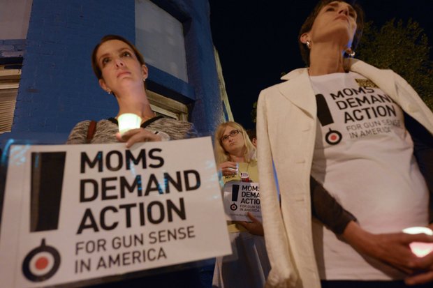 Shannon Watts (left), founder of Moms Demand Action, and Grace Terpstra stand in silence during a candlelight vigil for the victims of the Washington Navy Yard shooting at 8th and M streets in Southeast on Tuesday, Sept. 17.