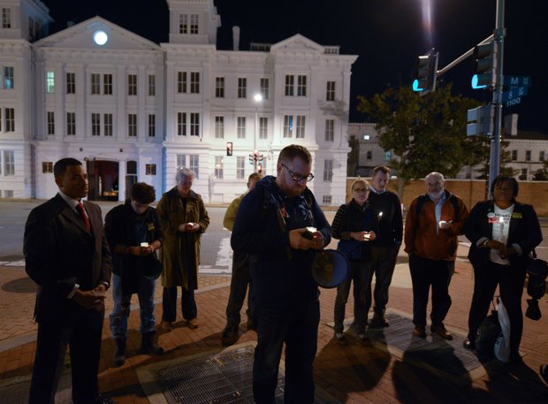 A small group stands in silence during a candlelight vigil for the victims of the Washington Navy Yard shooting at 8th and M streets in Southeast on Tuesday, Sept. 17.