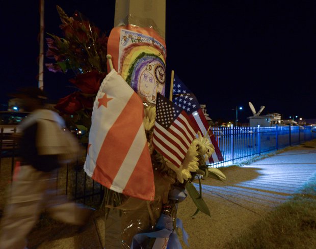 A man walks past a makeshift memorial at a lamppost on M Street in Southeast honoring the Washington Navy Yard victims on Tuesday, Sept. 17.