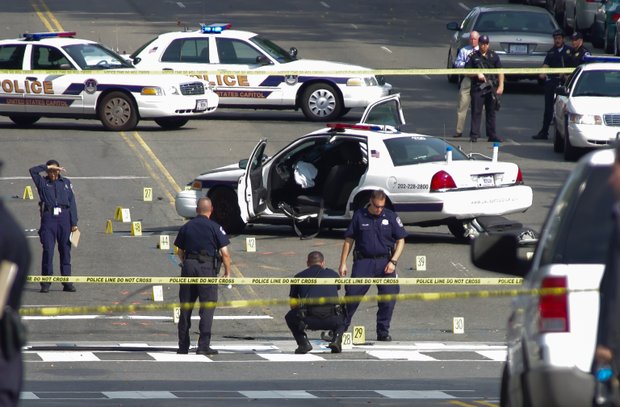 Authorities collect evidence from the scene on Thursday after a woman was shot to death following a high-speed chase on Capitol Hill.