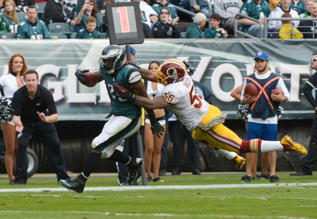 Philadelphia Eagles running back LeSean McCoy is tackled by Washington Redskins inside linebacker Perry Riley. McCoy earned the NFL’s rushing record during the game.