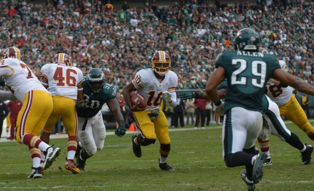 Washington Redskins quarterback Roberts Griffin, III splits through Eagles defenders for a short gain in the 2nd quarter. After 4th quarter comeback attempt the Redskins fell to the Eagles 16-24.
