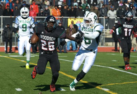 H.D. Woodson running back Jai Carson stiff-arms Wilson defensive back Mathew Thorne during the 44th Annual Turkey Bowl, a Thanksgiving tradition, in Southeast on Thursday, Nov. 28. H.D. Woodson defeated Wilson, 25-13.