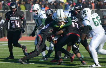 H.D. Woodson defenders stop Wilson running back Larry Frazier during the 44th Annual Turkey Bowl, a Thanksgiving tradition, in Southeast on Thursday, Nov. 28. H.D. Woodson defeated Wilson, 25-13.