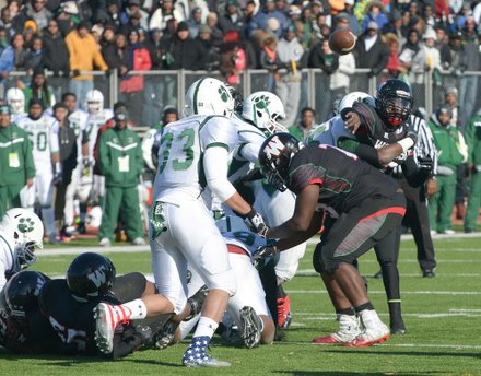 H.D. Woodson quarterback Rashad Cooper gets hit after releasing a pass in the fourth quarter during the 44th Annual Turkey Bowl, a Thanksgiving tradition, in Southeast on Thursday, Nov. 28. H.D. Woodson defeated Wilson, 25-13.