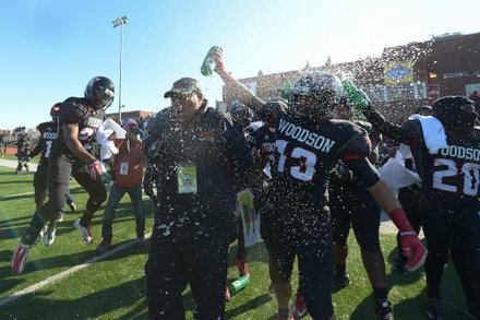 H.D. Woodson head coach Steven Scott (center) is drenched by his players after winning the 44th Annual Turkey Bowl, a Thanksgiving tradition, in Southeast on Thursday, Nov. 28. H.D. Woodson defeated Wilson, 25-13.