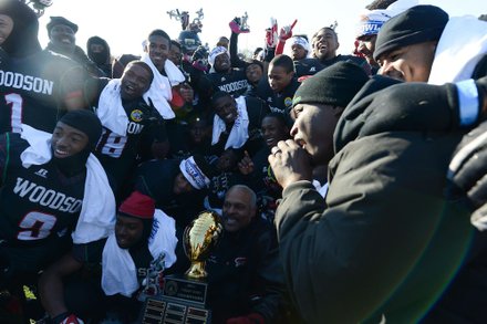 Former H.D. Woodson football head coach Gregg Fuller (center) poses with the team after it defeated Wilson High, 25-13, in the 44th Annual Turkey Bowl, a Thanksgiving tradition, in Southeast on Thursday, Nov. 28.