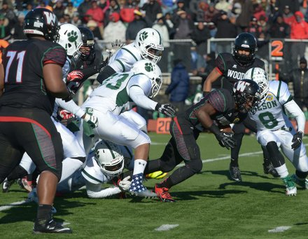 H.D. Woodson running back Jai Carson leans forward for extra yardage in the first quarter during the 44th Annual Turkey Bowl, a Thanksgiving tradition, in Southeast on Thursday, Nov. 28. H.D. Woodson defeated Wilson, 25-13.