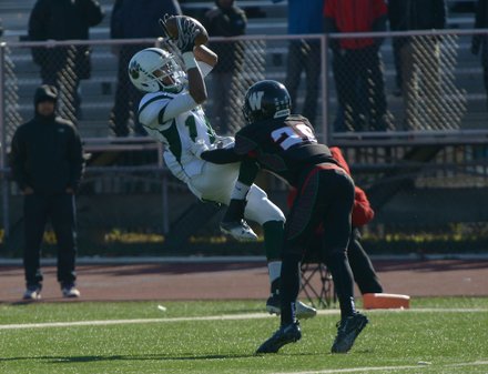 Wilson wide receiver Maurice Carter goes up and over H.D. Woodson defensive back Malik Gant for a second-quarter touchdown during the 44th Annual Turkey Bowl, a Thanksgiving tradition, in Southeast on Thursday, Nov. 28. H.D. Woodson defeated Wilson, 25-13.