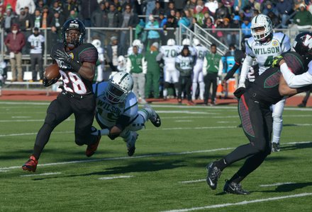 H.D. Woodson running back Jai Carson breaks a tackle by a Wilson defender in the first quarter of the 44th Annual Turkey Bowl, a Thanksgiving tradition, in Southeast on Thursday, Nov. 28. H.D. Woodson defeated Wilson, 25-13.