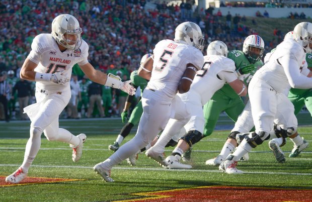 Maryland Terrapins quarterback C.J. Brown hands off to running back Albert Reid for a short gain in the first half of the 2013 Military Bowl on Friday, Dec. 27 at Jack Stephens Field at Navy-Marine Corps Memorial Stadium in Annapolis. The Marshall Thundering Herd defeated the Terrapins, 31-20.