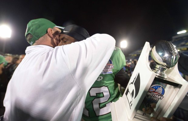 Marshall head coach Doc Holliday hugs quarterback Rakeem Cato after the 2013 Military Bowl on Friday, Dec. 27 at Jack Stephens Field at Navy-Marine Corps Memorial Stadium in Annapolis. The Marshall Thundering Herd defeated the Maryland Terrapins, 31-20.