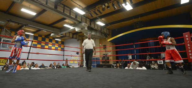Kesean Bagwell (left) and Lawrence Malcolm stand in their respective corners as referee Keith Jones readies to start the second round of a three-round amateur bout at the District Heights Classic, an annual amateur boxing event, at the District Heights Municipal Center on Saturday, Jan. 4. Bagwell won the fight by decision.