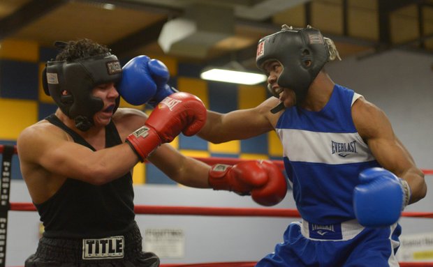 Gary Antwon Russell (right) lands a right hook against Tommy Avezar in the first round of their boxing match at the District Heights Classic, an annual amateur boxing event, at the District Heights Municipal Center on Saturday, Jan. 4. Russell won the match by decision.