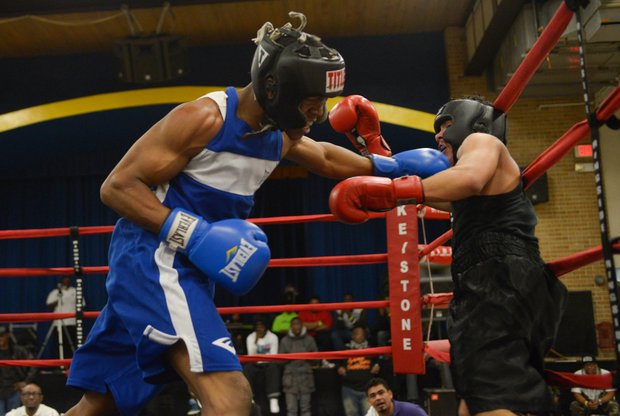 Gary Antwon Russell (left) lands a punch against Tommy Avezar in the third round of their boxing match at the District Heights Classic, an annual amateur boxing event, at the District Heights Municipal Center on Saturday, Jan. 4. Russell won the match by decision.