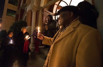 Pastor Lennox Abrigo leads a prayer during a candlelight vigil outside the Metropolitan A.M.E. Church in Northwest D.C. after the National Action Network-sponsored National Youth Day of Action Against Gun Violence summit on Wednesday, Jan. 8.