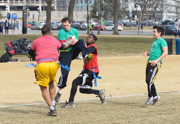 Chad B. catches a pass between two defenders during a flag football game on the National Mall in D.C. on Sunday, Feb. 2. The NAKID Winter Football League plays on the Mall on the weekends.