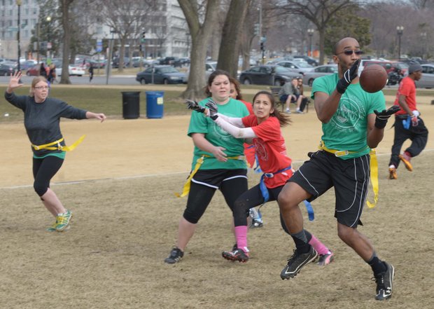 Albert Hailey catches a pass during a flag football game on the National Mall in D.C. on Sunday, Feb. 2. The NAKID Winter Football League plays on the Mall on the weekends.