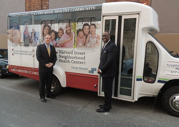 Harvard Street Neighborhood Health Center (HSNHC) unveiled its new shuttle bus that will help increase access to medical services. Patients that require care unavailable at the center will be transported to Carney Hospital in Dorchester. Shown are Charley Murphy, president and CEO of HSNHC (l) and Andy Davis, President and CEO of Carney Hospital.