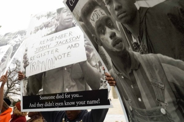 Demonstrators carry signage at the base of the U.S. Supreme Court building in D.C. during a rally for voting rights Wednesday, March 12.