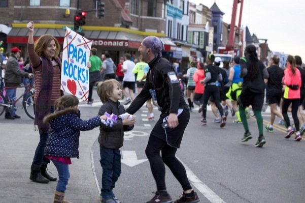 D.C. resident Eugene Vereta is greeted by his wife Anka Dadarlat and their children at the corner of 18th Street and Columbia Road in Northwest while he runs in the D.C. Rock 'n' Roll Marathon on March 15, 2014.