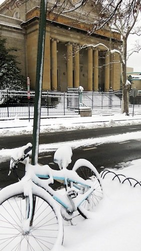 A bicycle chained to a street sign sits in front of the Christian Science Church in D.C.'s Adams Morgan neighborhood on March 17, 2014, after a winter storm hit the region.