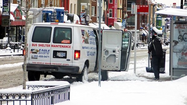 Bus shelter maintenance workers in D.C. remove snow and ice on March 17, 2014, after a winter storm hit the region.
