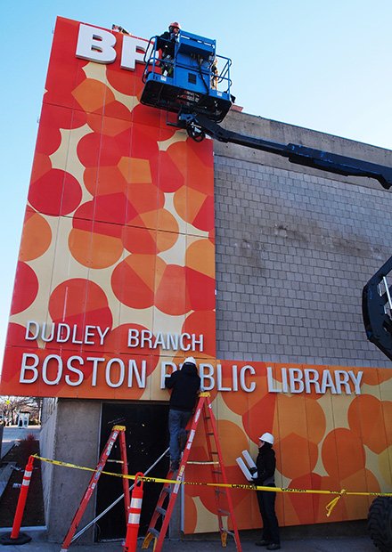 A new look for the Dudley Library: Workers install lettering on the side of the Dudley Branch of the Boston Public Library’s new façade. The new design will be backlit with luminous lettering.