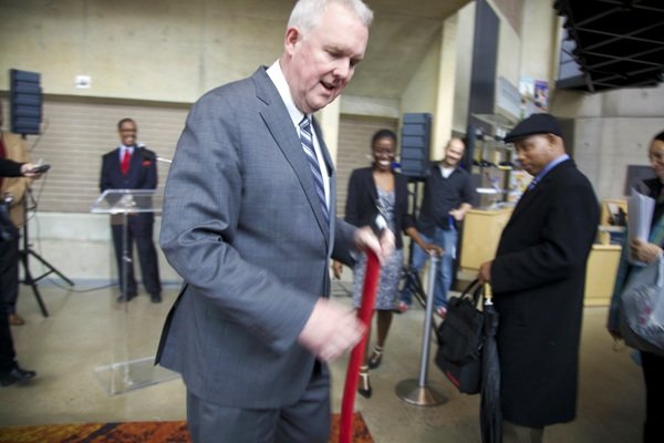 D.C. Council member Tommy Wells removes the rope to let job seekers into the D.C. Job Fair on March 28 at the Mead Center for American Theater in Southwest.