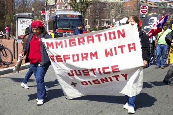 Two participants in a rally in D.C. for immigrant rights hold a sign while marching from Mount Pleasant Street NW to the White House on April 5, 2014.