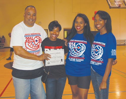 Joyce Washington Classic Director and Portland Observer Publisher Mark Washington, joins classic volunteers Quayana Washington and Shay Washington to present a donation from the charity game to Jenita Jones of the Portland Track Club.