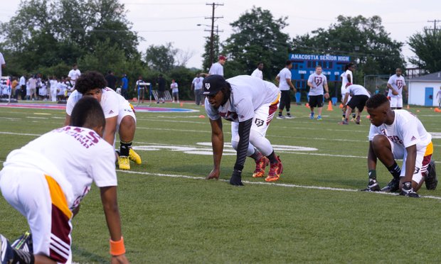 Robert Griffin III helps camp participants with drills during his first-ever "Friday Night Lights" football camp at Anacostia Senior High on Friday, June 13.