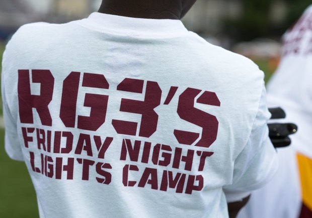 A young child sports the RGIII Friday Night Lights shirt before the start of Robert Griffin III first-ever "Friday Night Lights" football camp at Anacostia Senior High on Friday, June 13. Khalid Naji-Allah