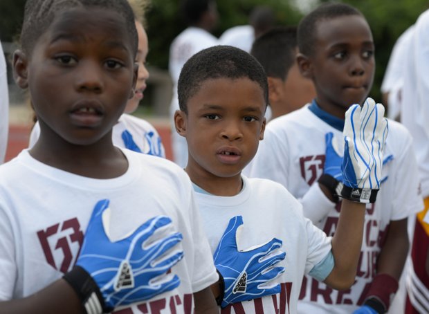 Camp participants say the Pledge of Allegiance before the start of Robert Griffin III first-ever "Friday Night Lights" football camp at Anacostia Senior High on Friday, June 13.